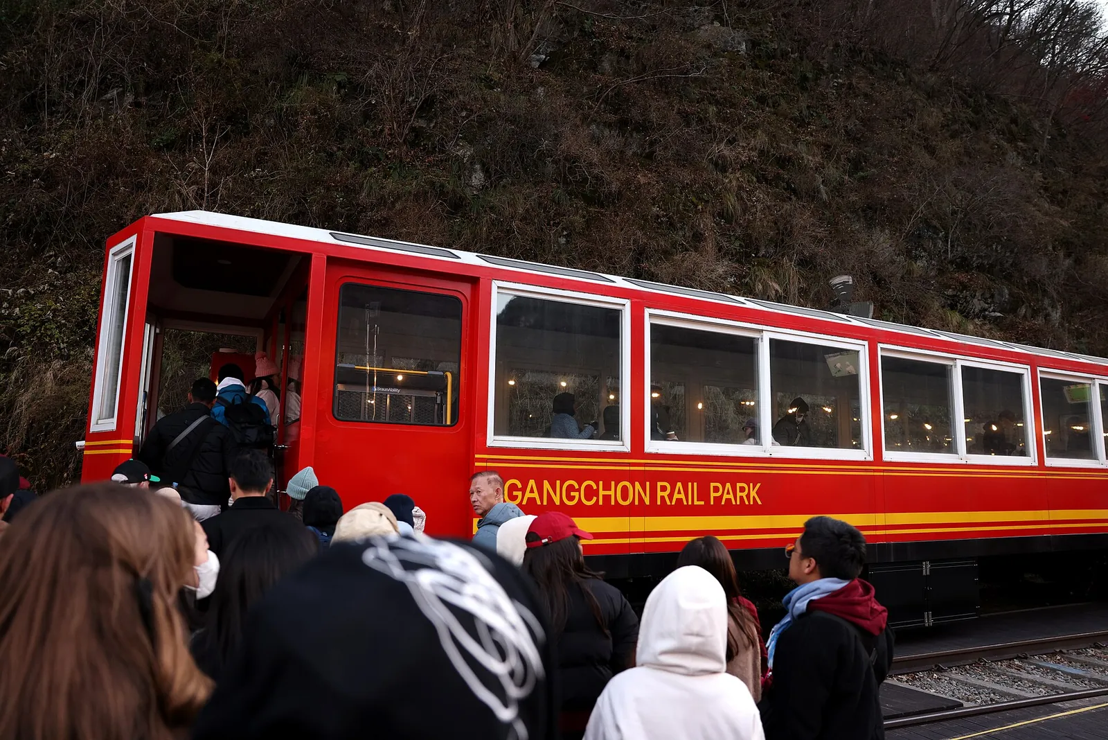Visitors boarding the red Gangchon Rail Park train in Chuncheon