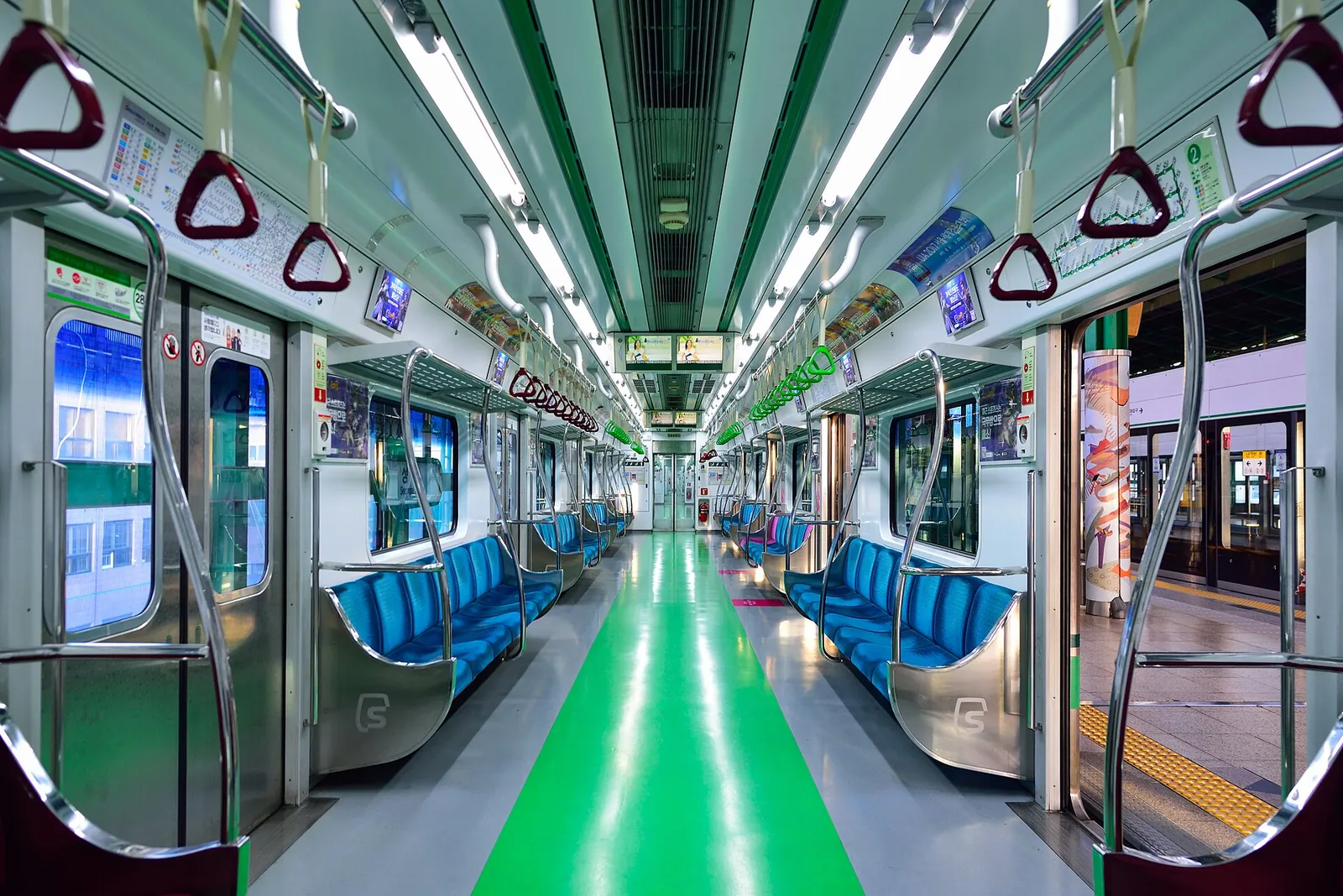 Interior of a Seoul Metro Line 2 train with blue seats and a green floor stripe