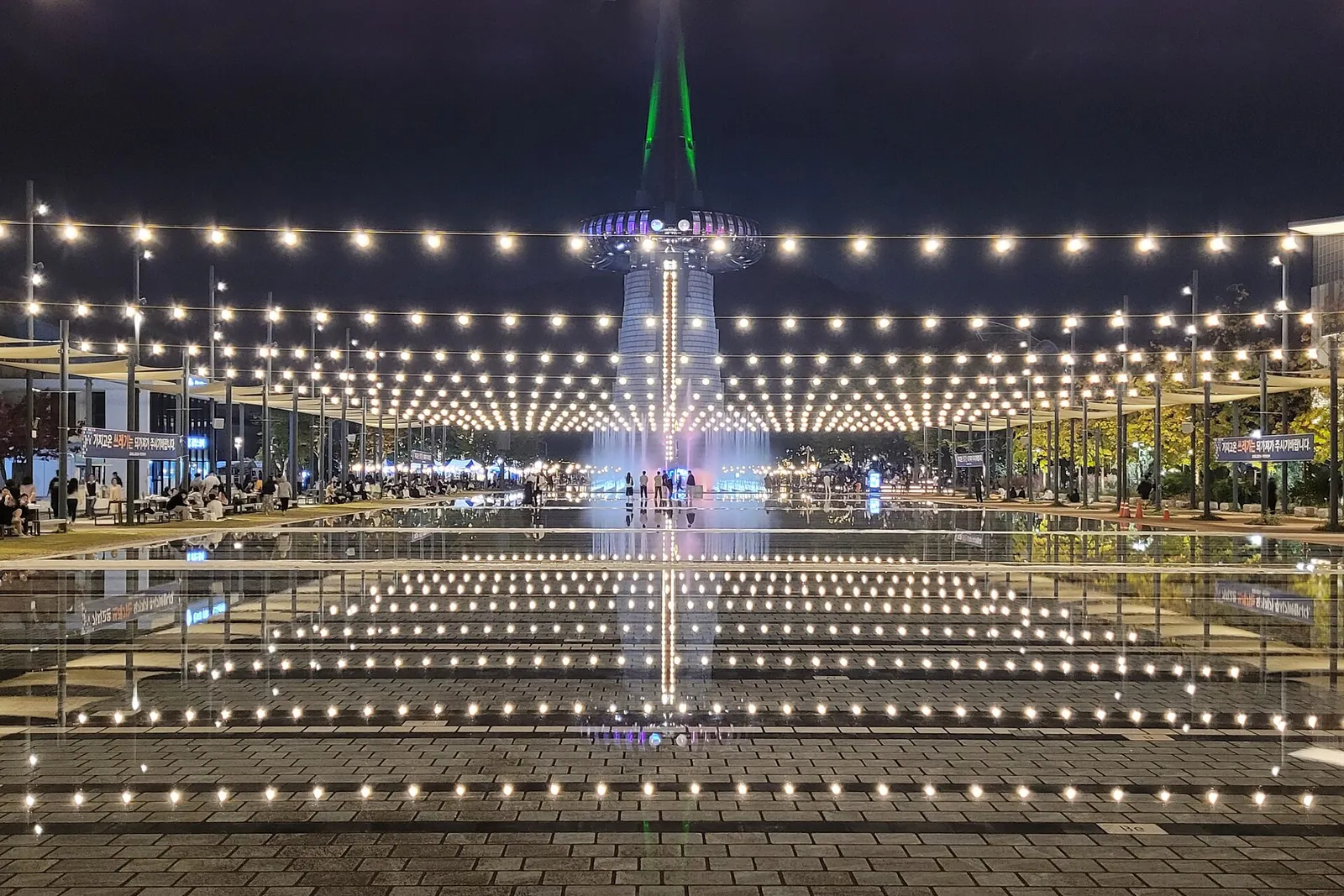Hanbit Tower lit up at night above the illuminated plaza and pools of Expo Science Park, Daejeon