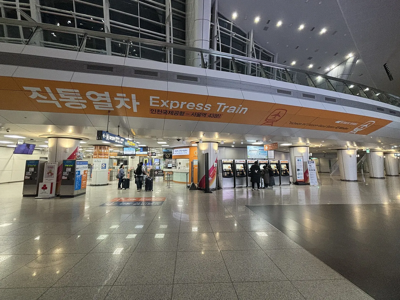 AREX Express Train concourse at Incheon International Airport Terminal 1 with ticket machines and an orange Express Train sign