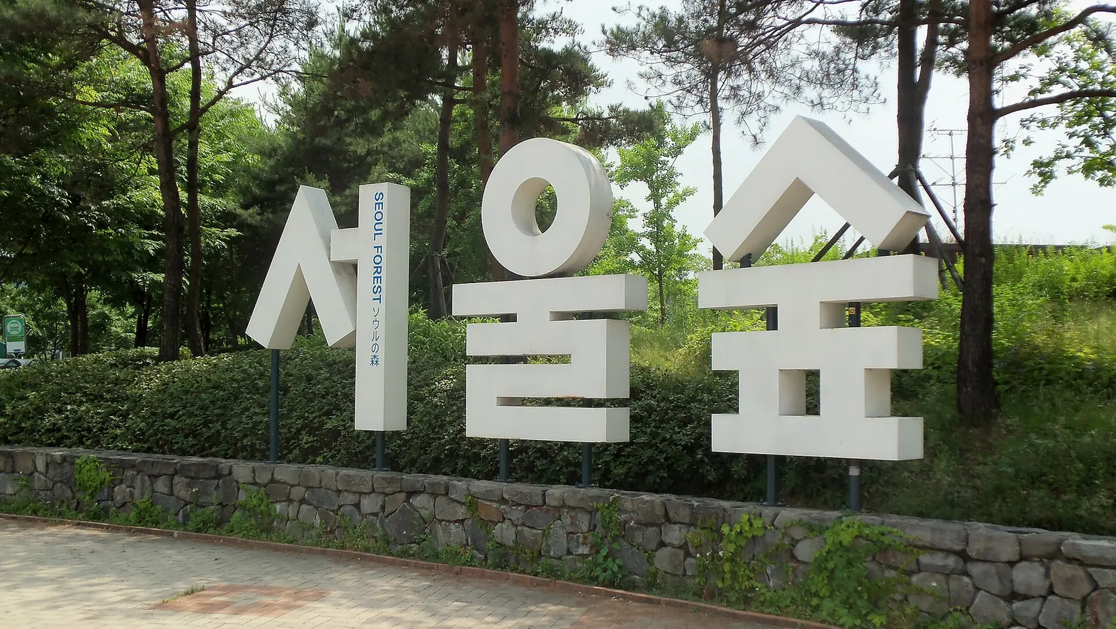 The large white Seoul Forest sign in front of trees and a paved path