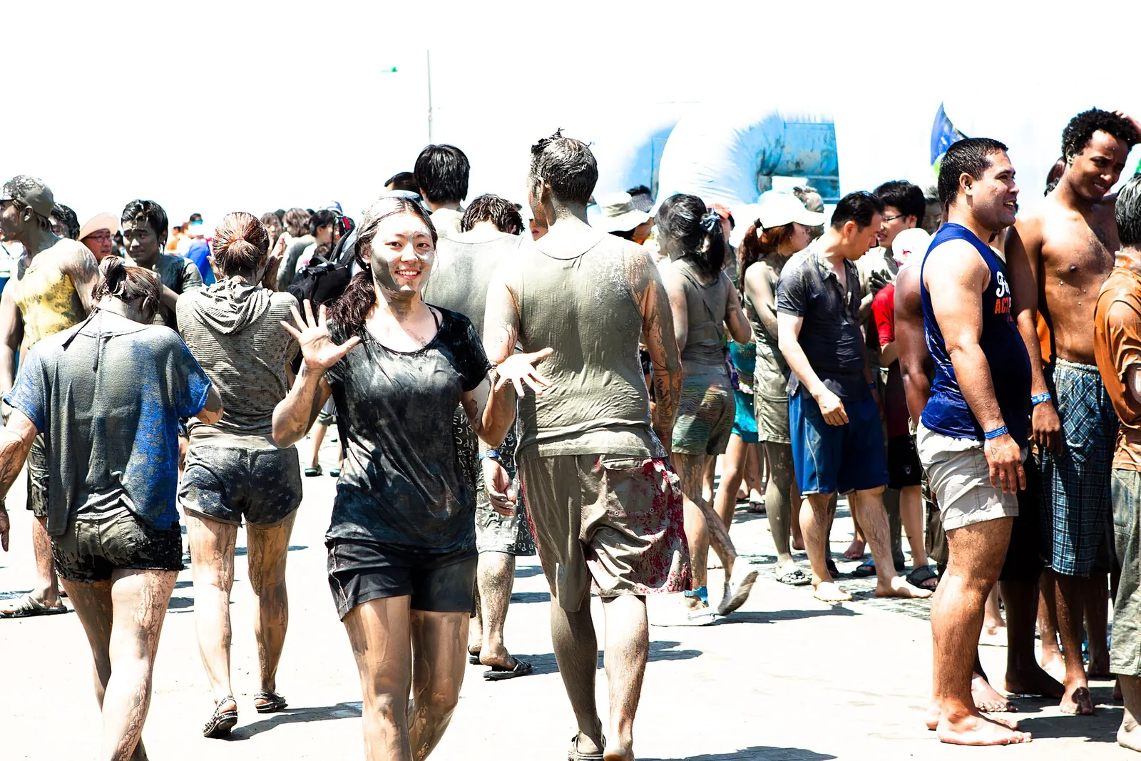 A crowd of mud-covered visitors walking along Daecheon Beach during the Boryeong Mud Festival