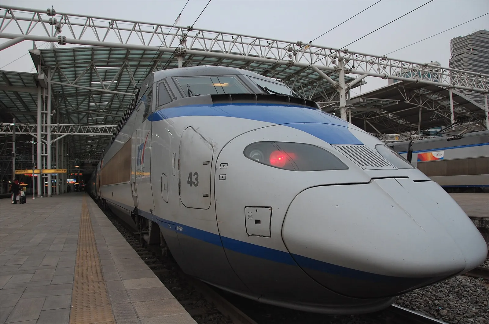A white and blue KTX high-speed train waiting at a platform in Seoul Station