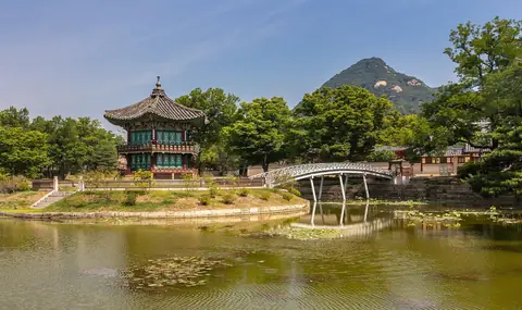 Hyangwonjeong-pavillonen på sin dam ved Gyeongbokgung-paladset i Seoul under en blå himmel