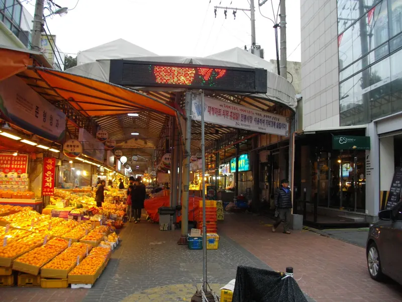 Stalls piled with citrus fruit in trays at the entrance to Dongmun Market in Jeju City