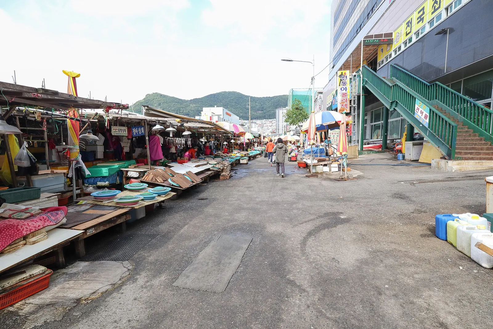 Street stalls under awnings along the waterfront road outside Jagalchi Market in Busan
