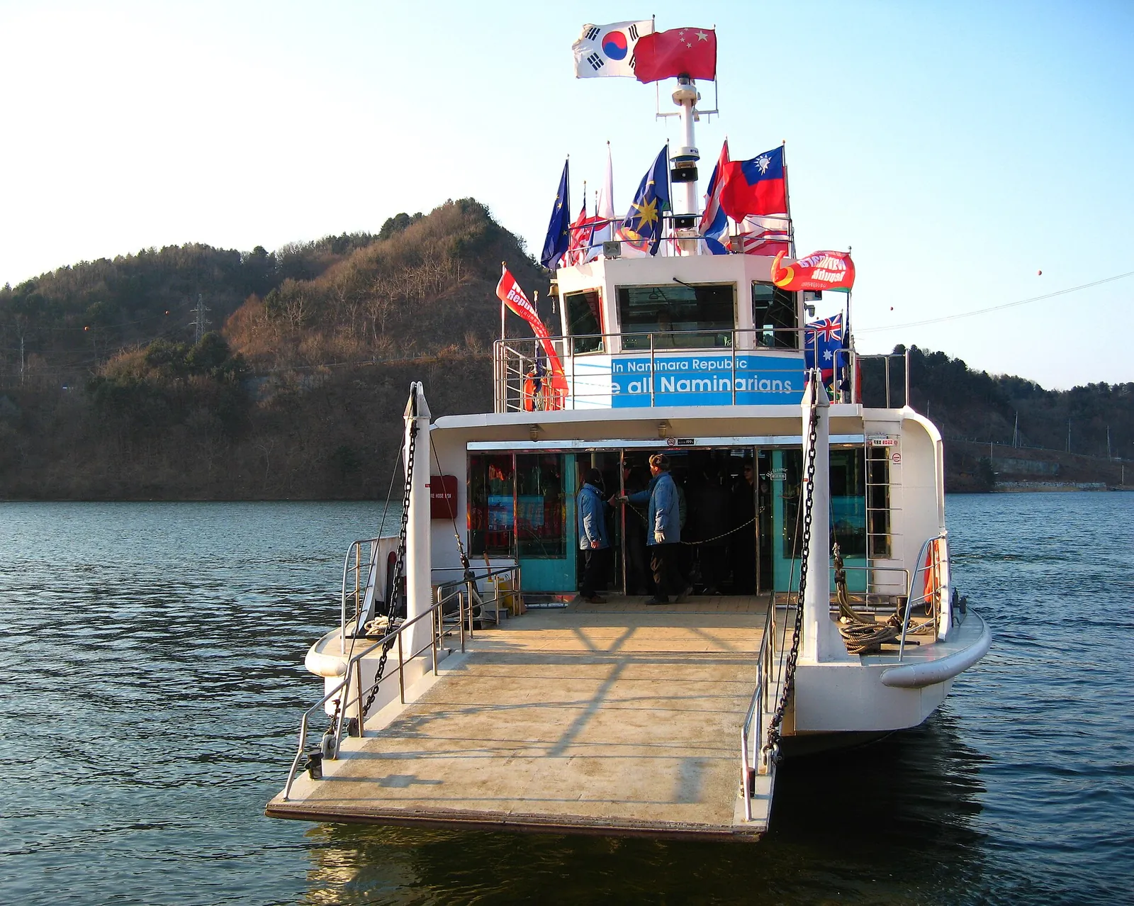 White passenger ferry decked with national flags moored at the Nami Island pier