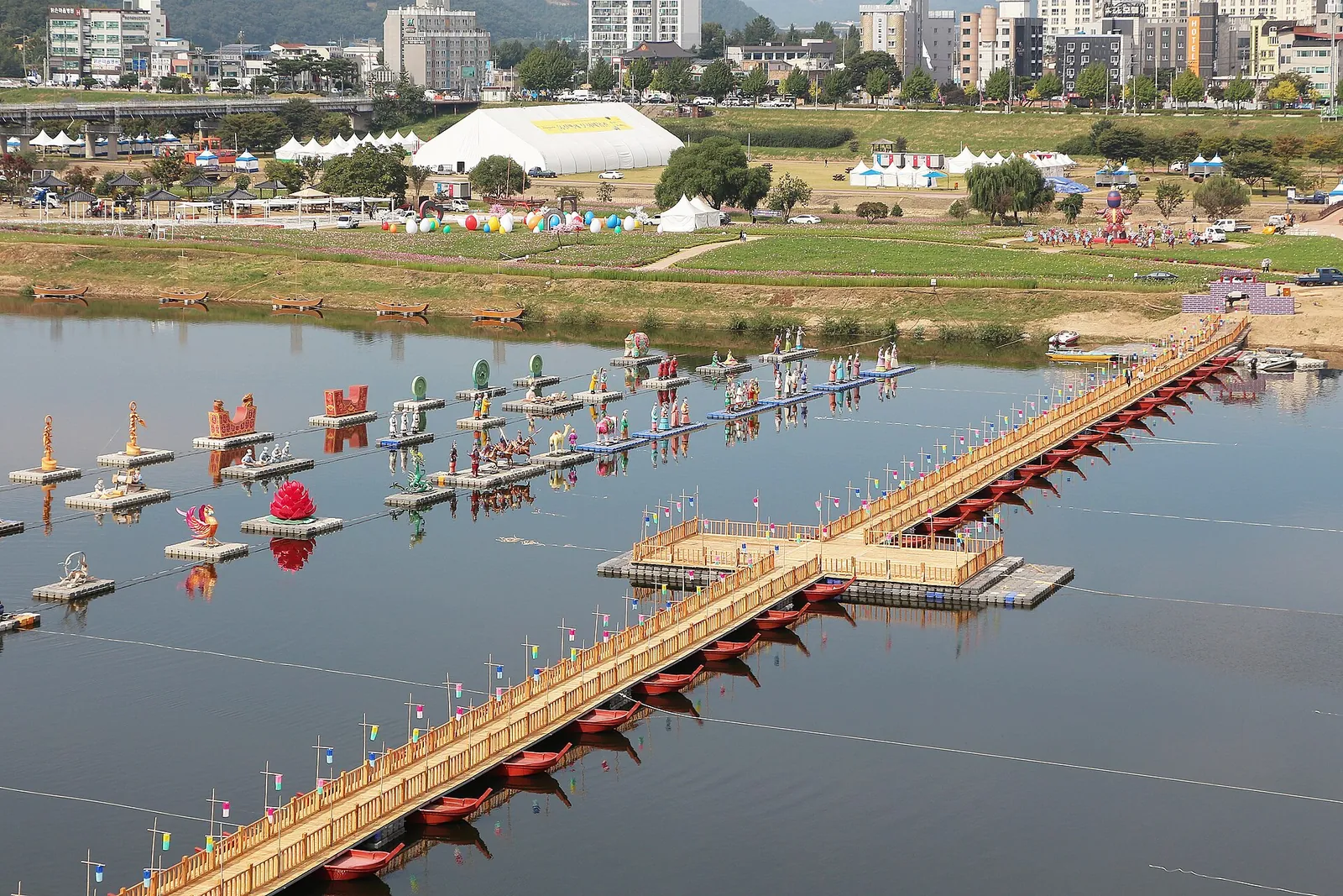 Floating walkway and lantern figures on the Geumgang River in Gongju with the city beyond