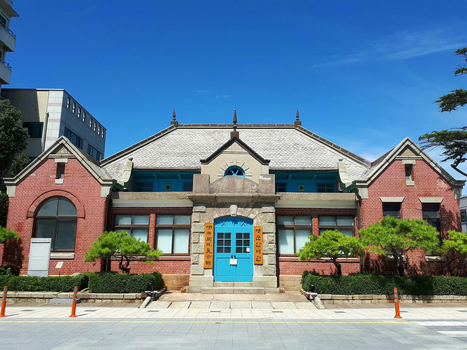 Red-brick Former Gunsan Customs building with a blue central door under a clear blue sky