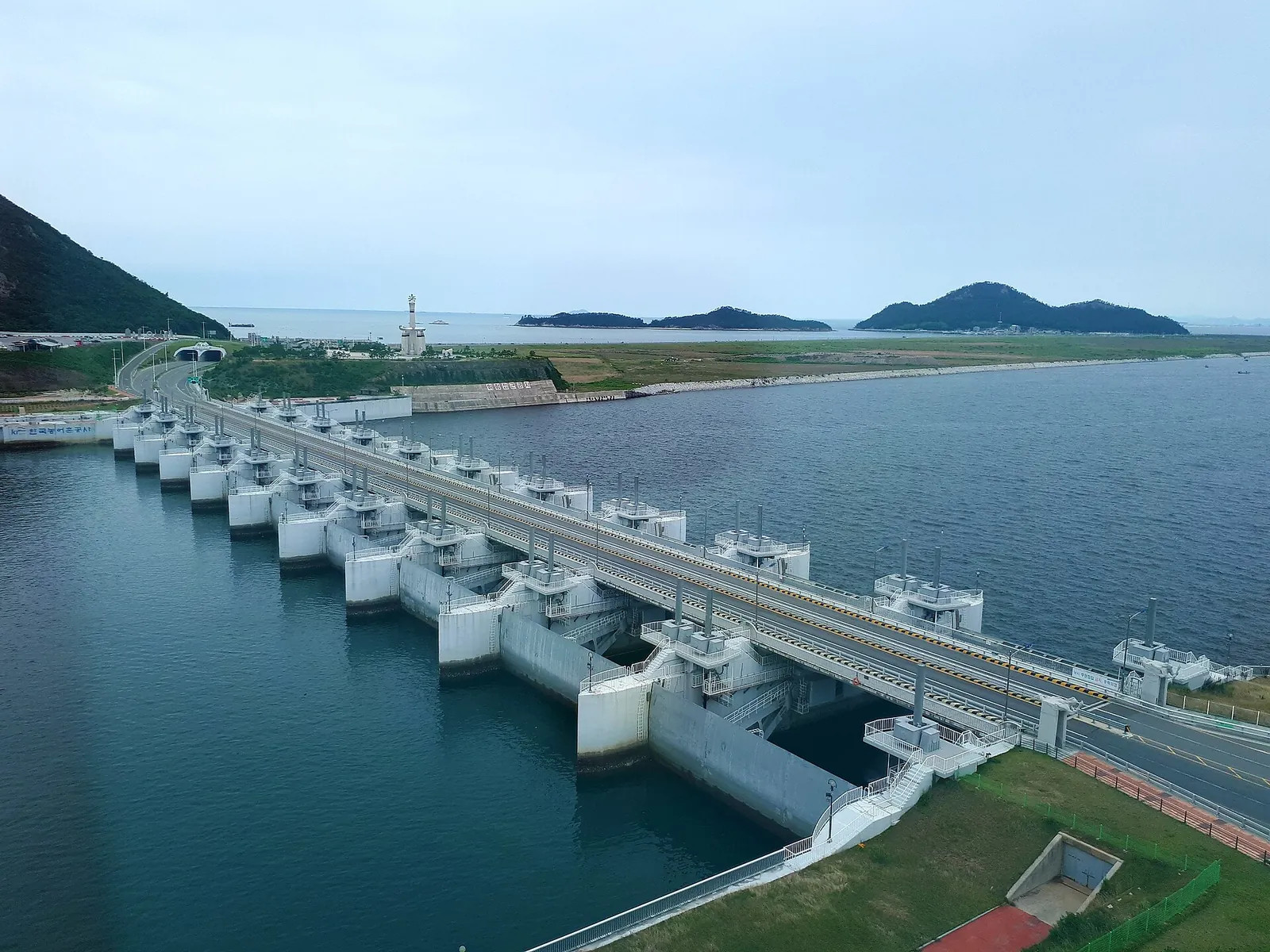 Row of sluice gates on the Saemangeum seawall leading out to small islands in the sea