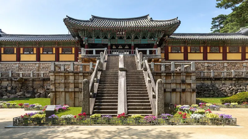 Stone stairways and bridges leading up to the gate of Bulguksa Temple in Gyeongju, with flower beds in front