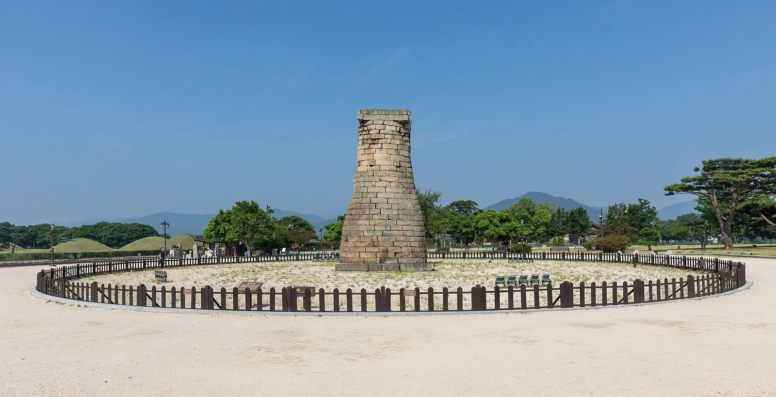 Cheomseongdae, a bottle-shaped stone observatory, inside a low fence on open ground in Gyeongju