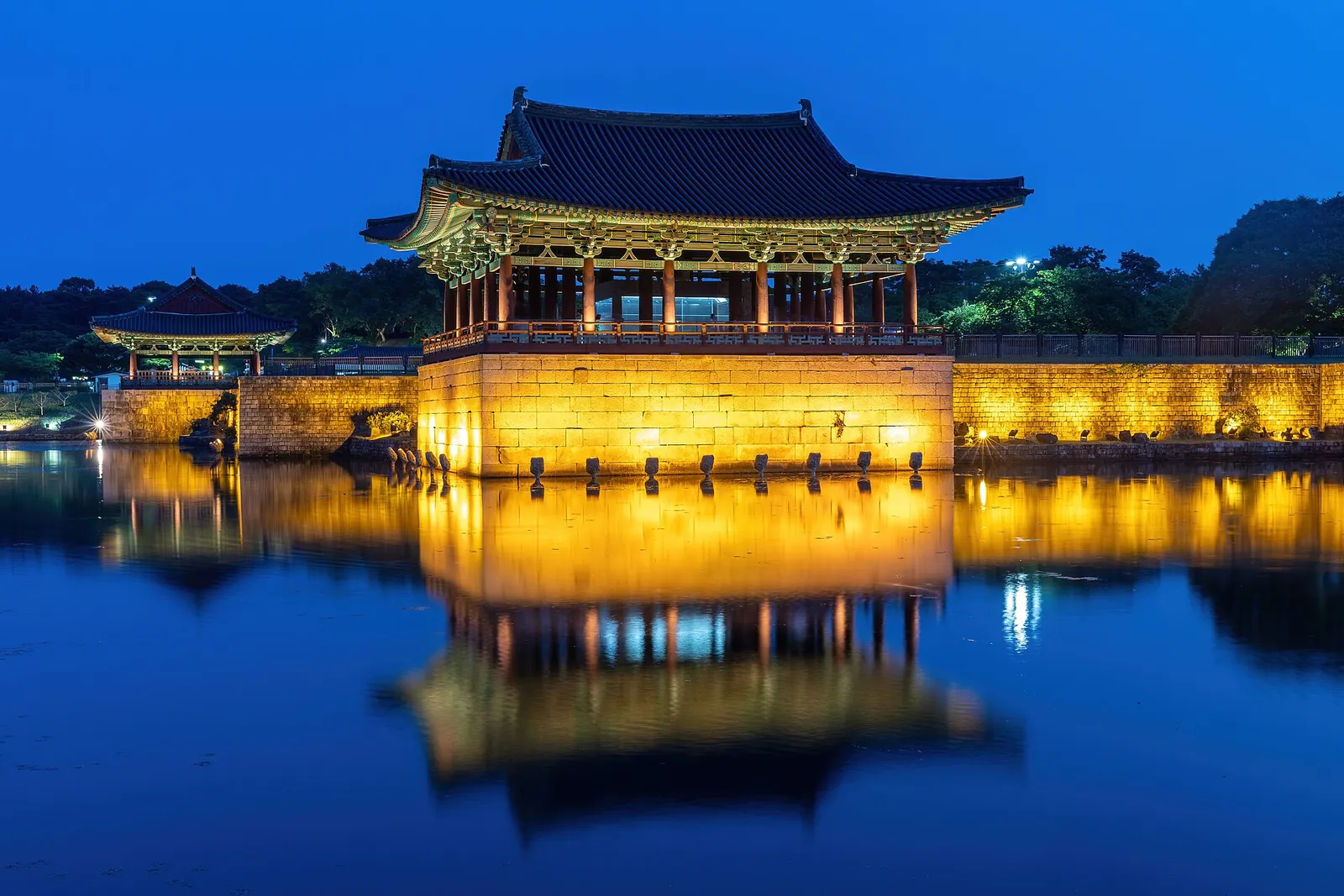 Pavilions of Donggung Palace lit up and reflected in Wolji Pond at blue hour