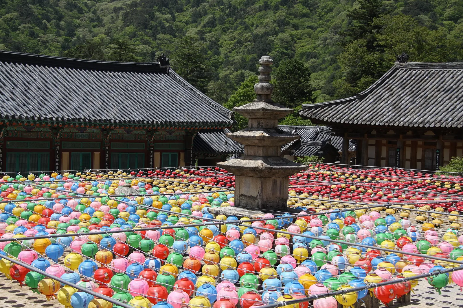 Rows of colourful paper lanterns around a stone pagoda in the Haeinsa courtyard
