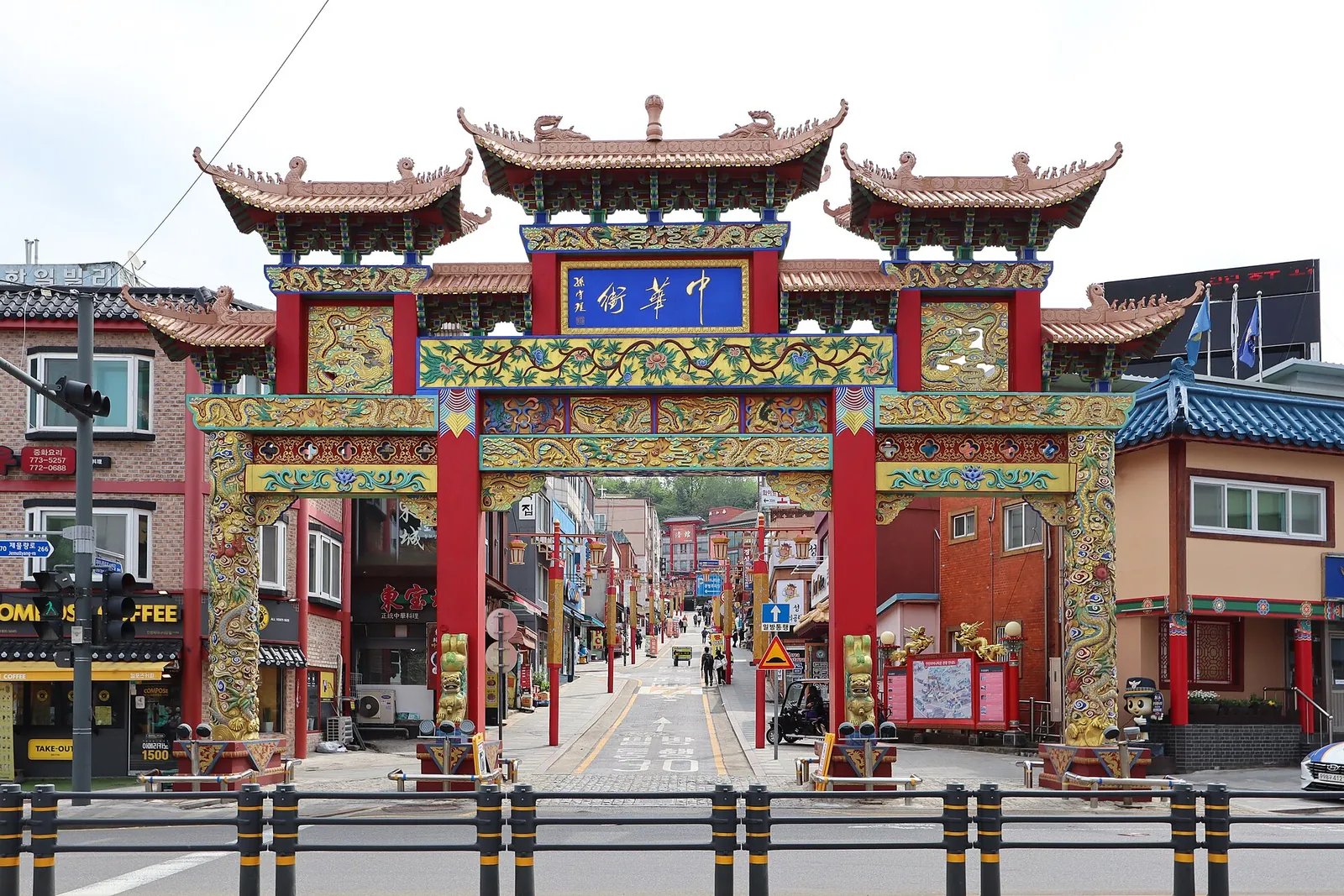 Ornate red and gold paifang gate at the entrance to Incheon Chinatown, with the street beyond
