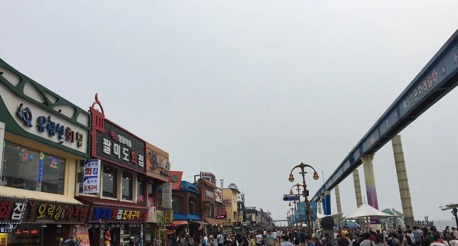 Seafront promenade on Wolmido with seafood restaurants on one side and the elevated Wolmi Sea Train track overhead