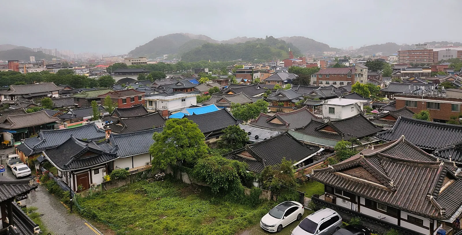 Rooftops of traditional hanok houses packed together in Jeonju Hanok Village, with hills beyond