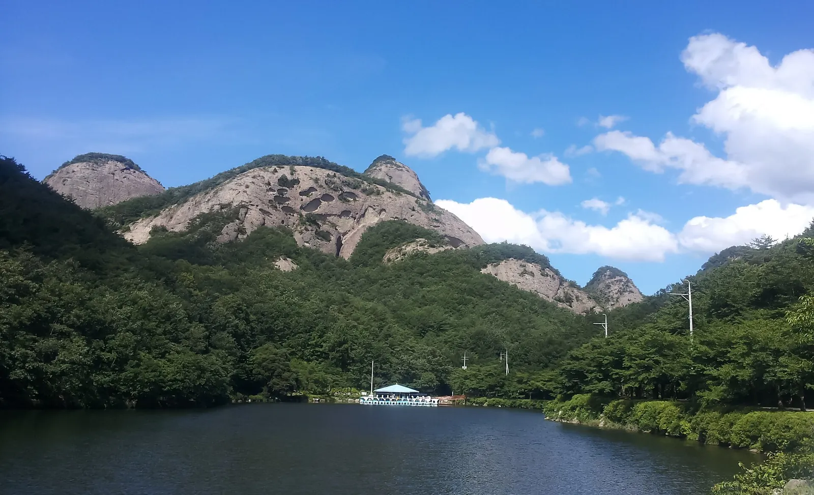 A lake below the jagged rocky peaks of Maisan Provincial Park on a sunny day
