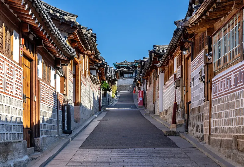 Bukchon-ro 11-gil, a sloping lane lined with tiled-roof hanok houses under a blue sky