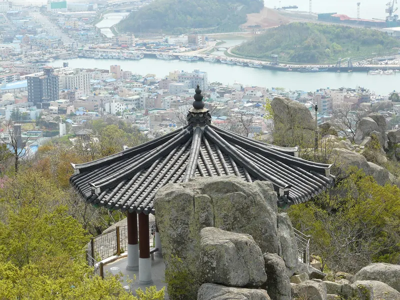 Traditional pavilion among granite rocks on Yudalsan, with Mokpo's rooftops and harbour below
