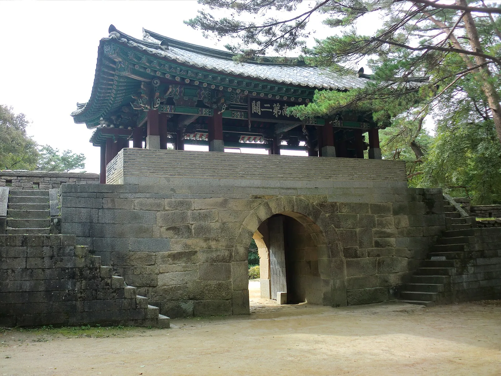Jogokgwan, the second gate of Mungyeong Saejae, a stone gateway with a tiled two-storey pavilion among pine trees