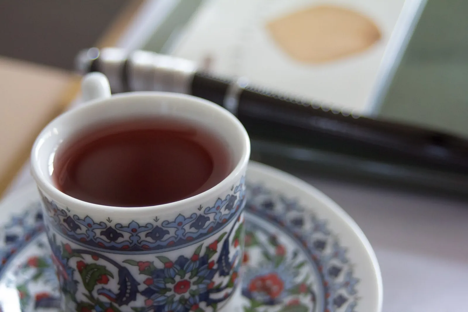 A cup of red omija-cha, five-flavour berry tea, on a patterned saucer