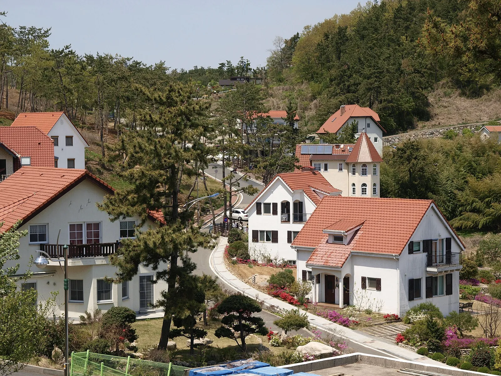White German-style houses with red roofs on a wooded hillside at the German Village in Namhae
