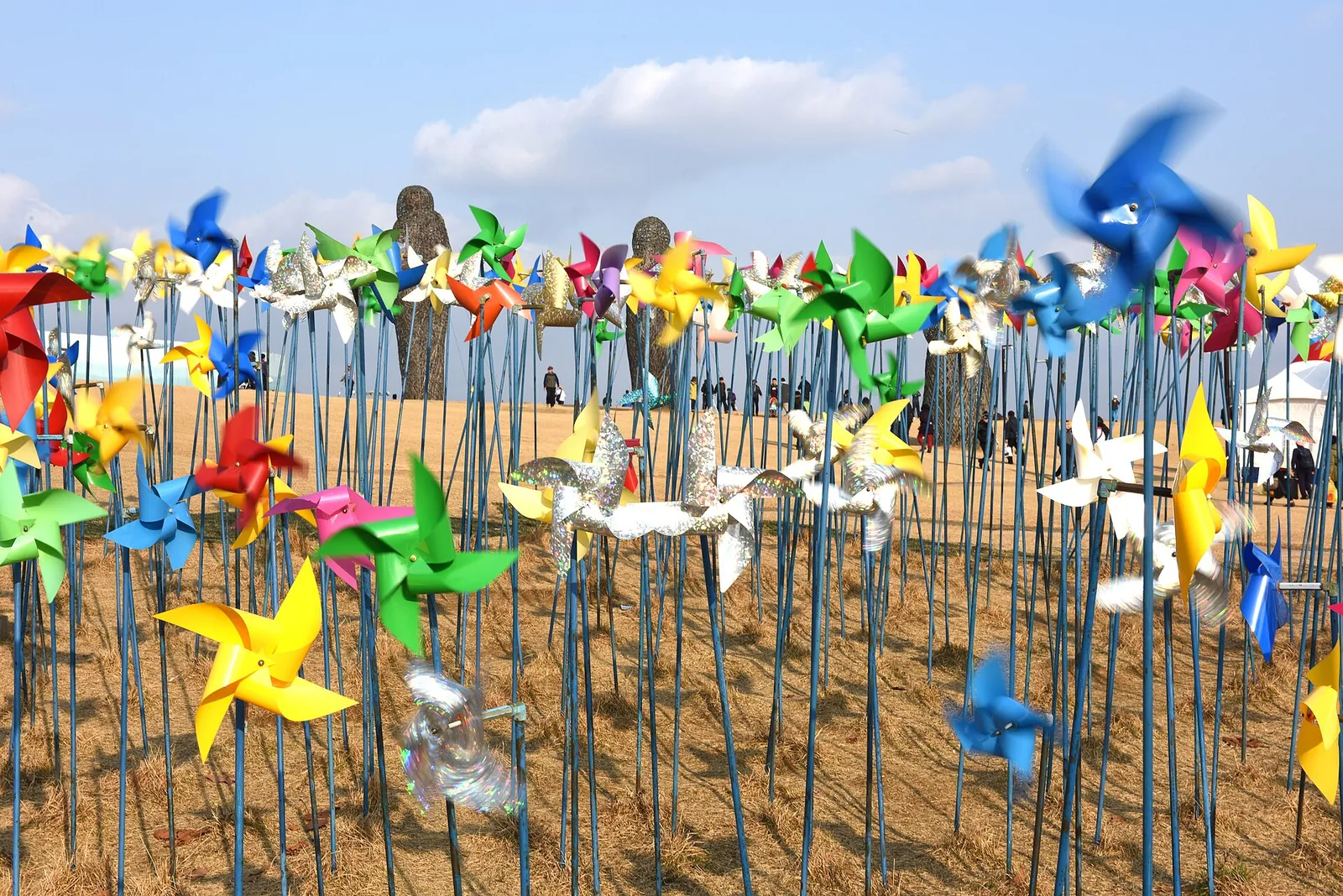 Rows of colourful pinwheels on a hillside under a blue sky at Pyeonghwa Nuri Park, Imjingak