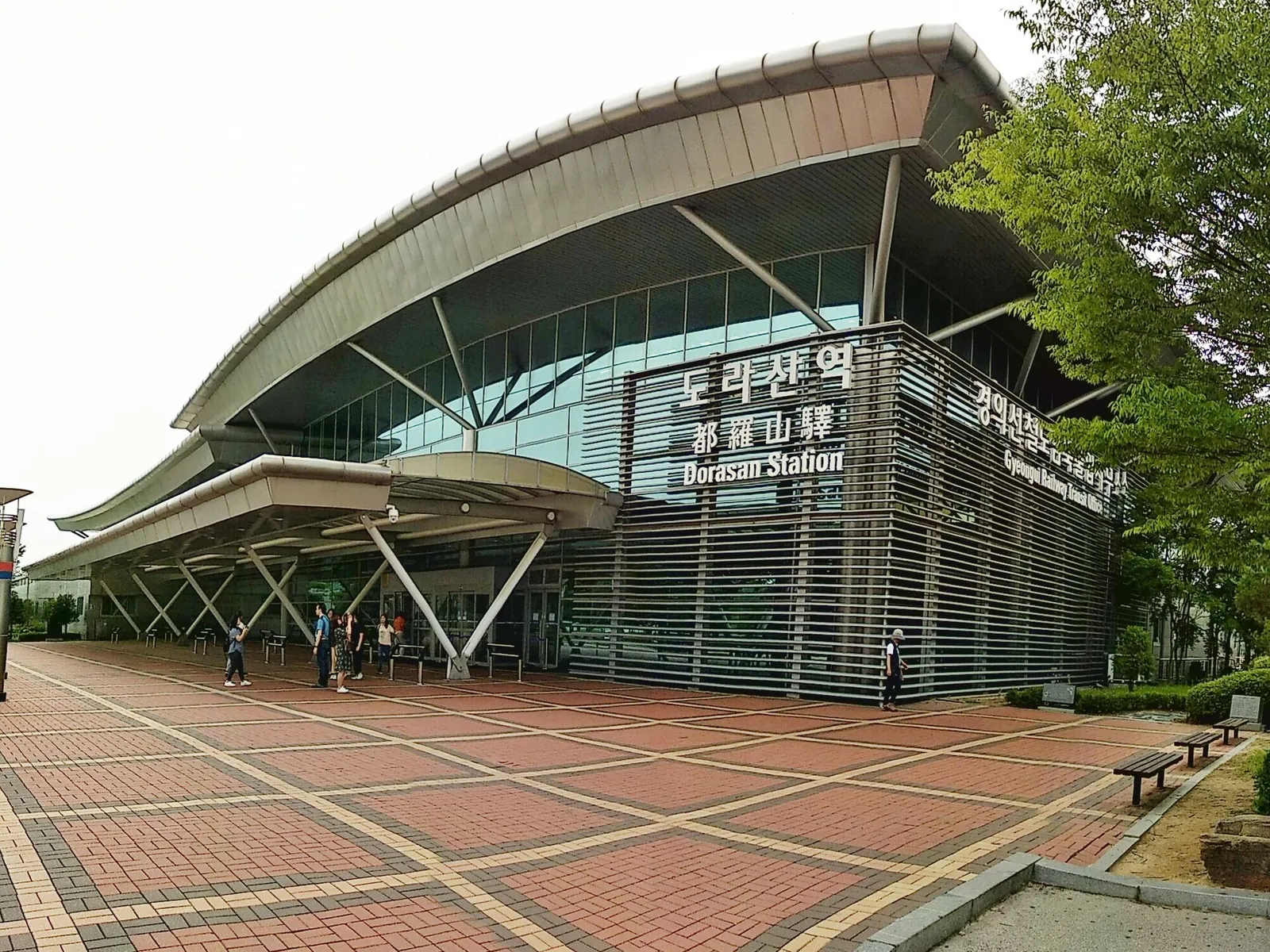Curved glass-and-steel roof of Dorasan Station with its name in Korean, Chinese and English
