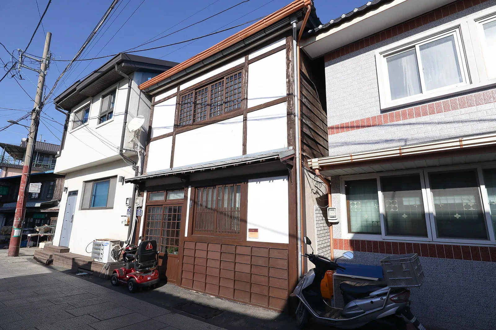 Two-storey wooden Japanese-style houses with tiled roofs on a narrow lane in Guryongpo