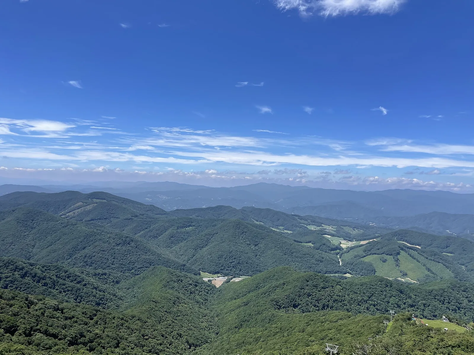 Forested mountain ridges stretching to the horizon under a blue sky, seen from Balwangsan