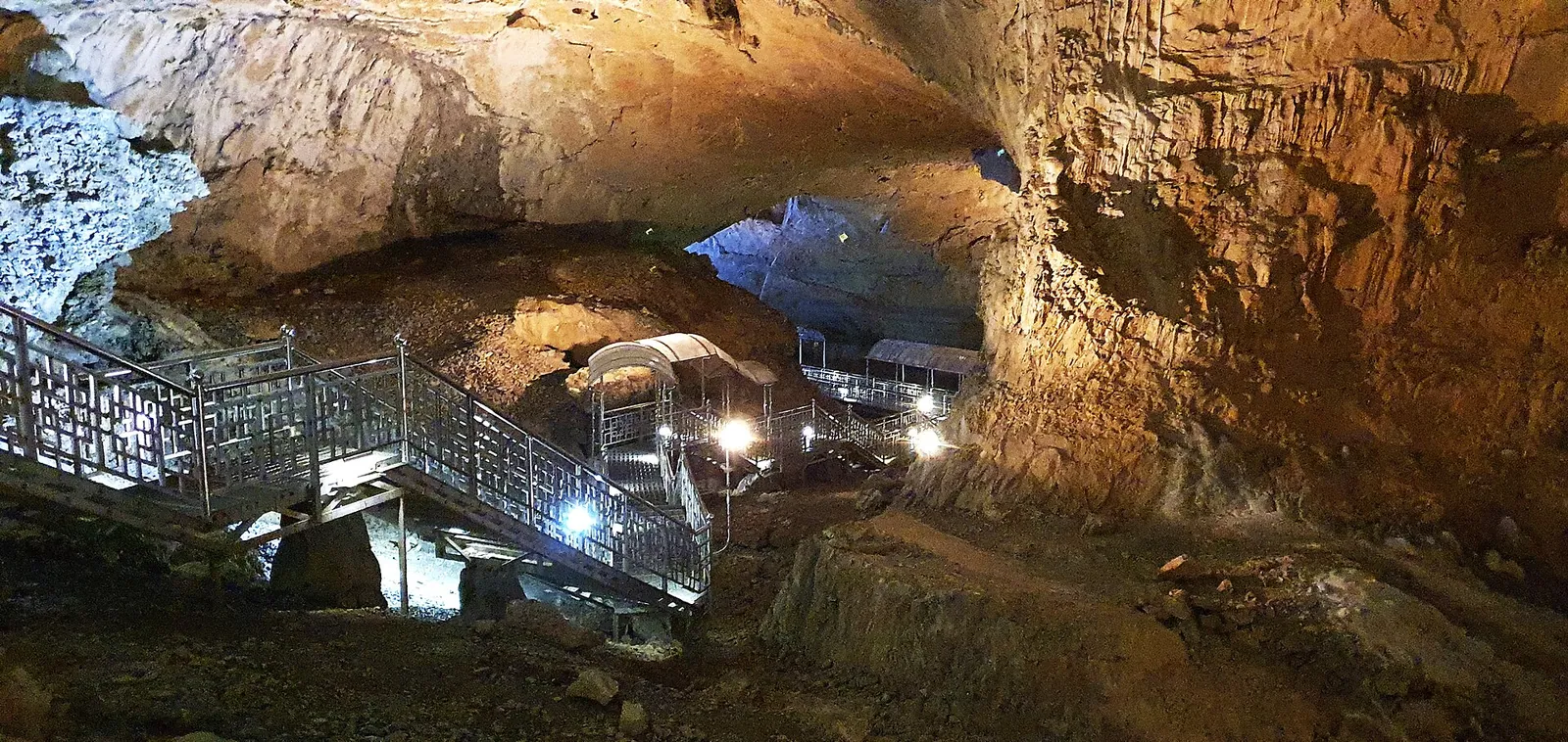 Lit walkways and stairs winding through a huge limestone chamber inside Hwanseongul Cave