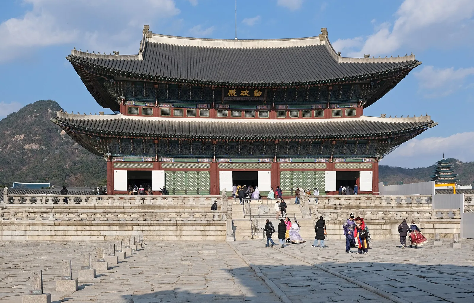 Geunjeongjeon, the throne hall of Gyeongbokgung Palace, on its stone terrace under a blue sky with Bugaksan behind