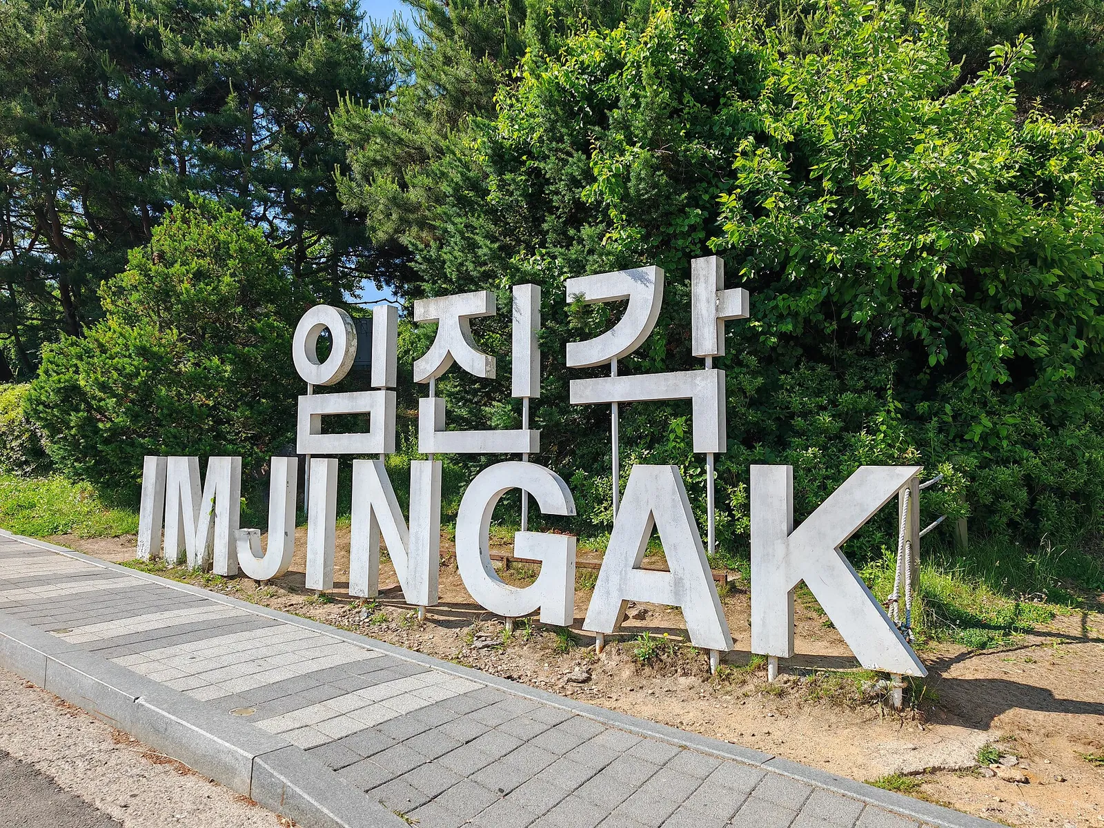 Large IMJINGAK letters in Korean and English beside a path with trees behind
