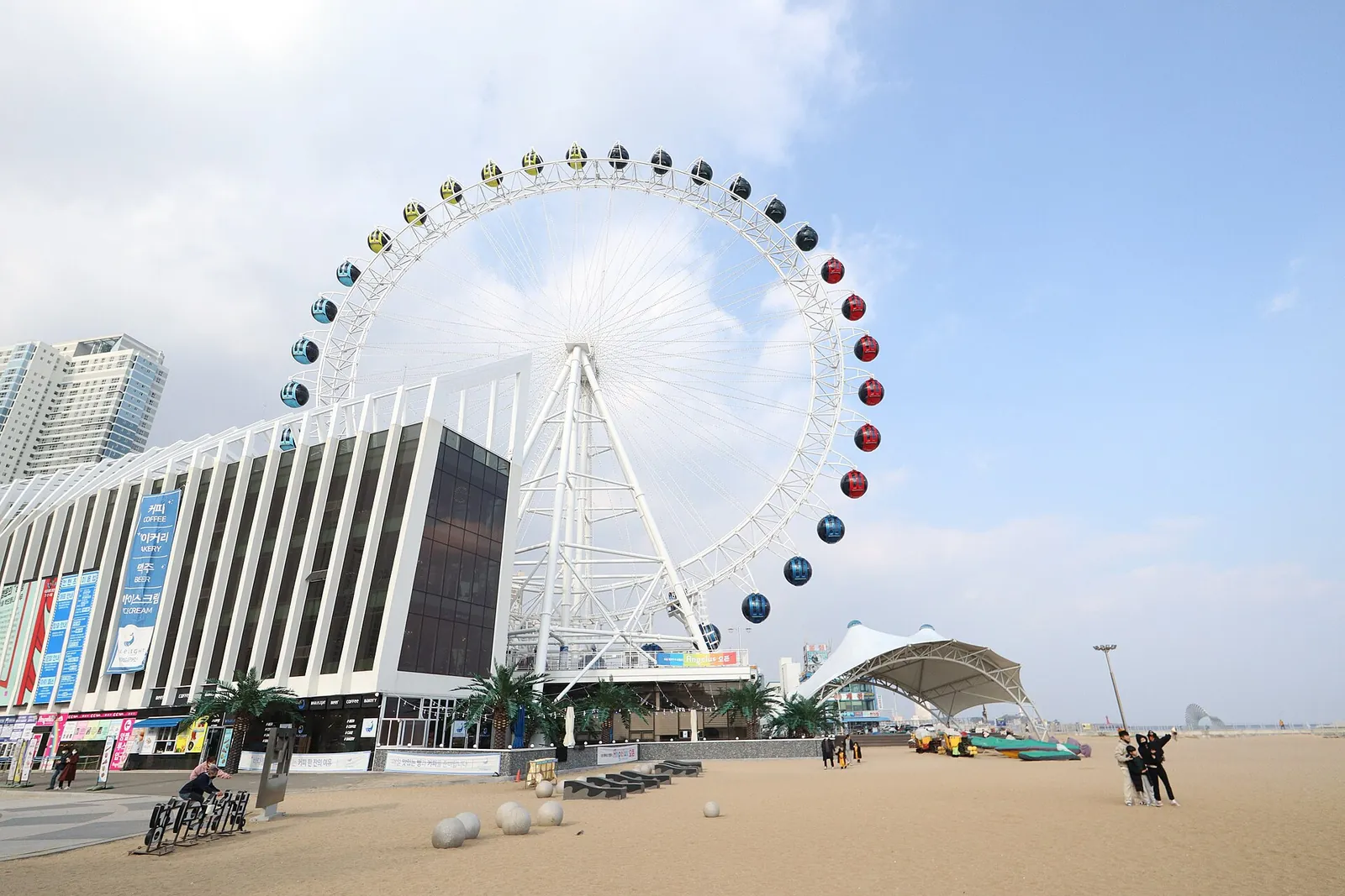 The Sokcho Eye Ferris wheel beside a building at the edge of Sokcho Beach