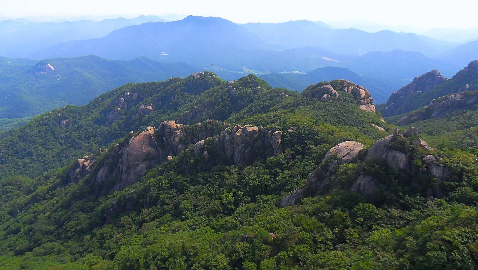 Granite peaks and forested ridges of Songnisan seen from the rock platform of Munjangdae