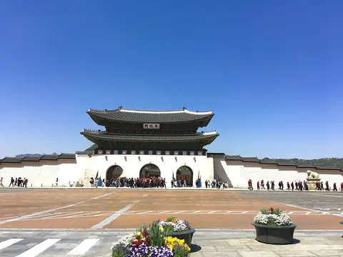 Gwanghwamun, den sydlige port til Gyeongbokgung-paladset i Seoul, set over Gwanghwamun-pladsen under en blå himmel