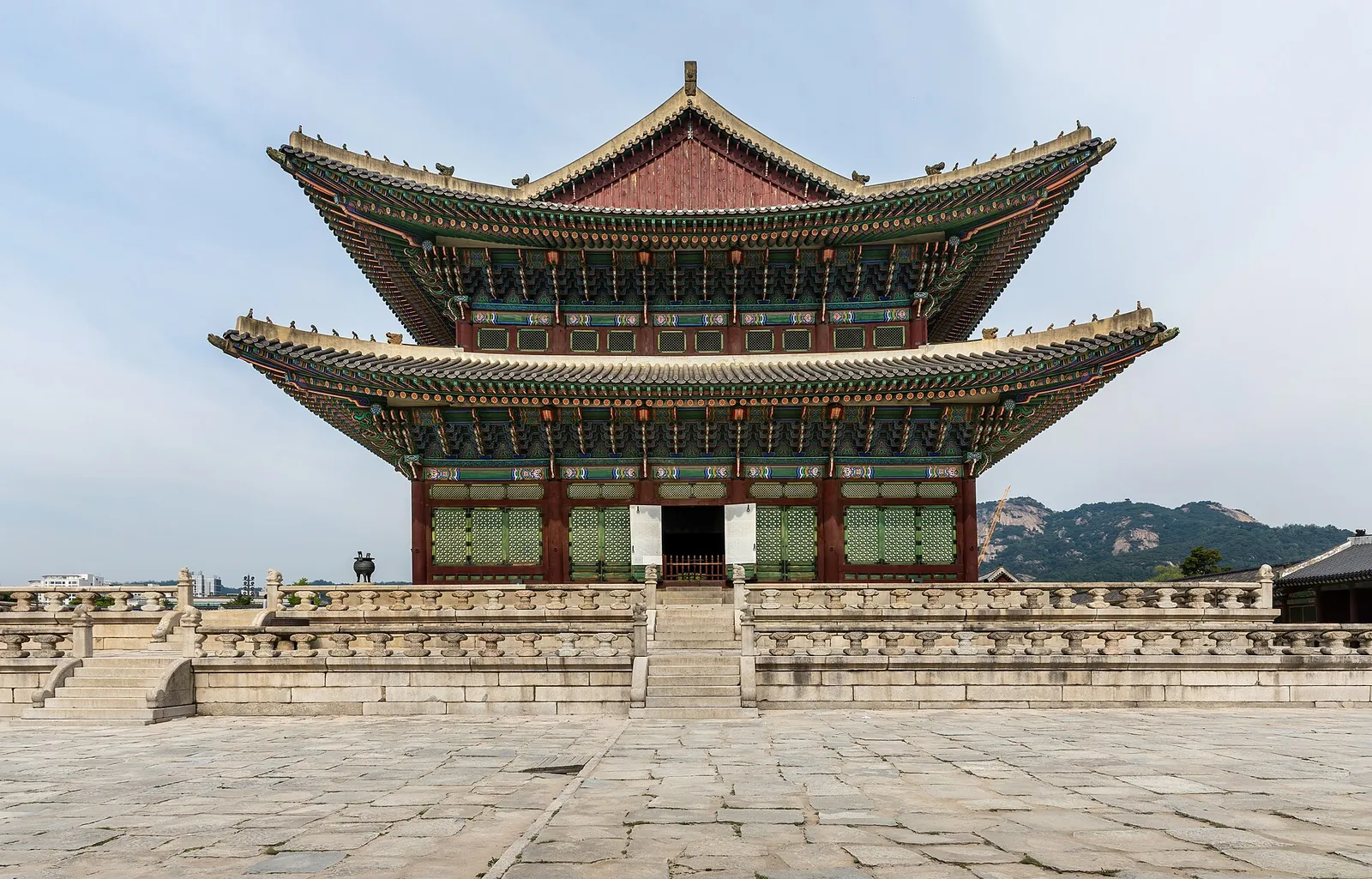 Geunjeongjeon, the two-tiered throne hall of Gyeongbokgung Palace, on its stone terrace under a blue sky