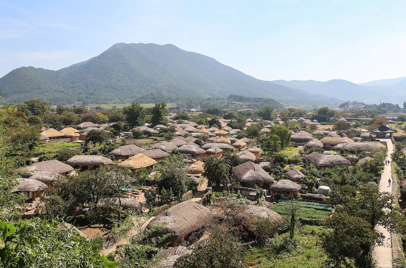 Thatched-roof houses of Naganeupseong Walled Town spread across a valley below green mountains