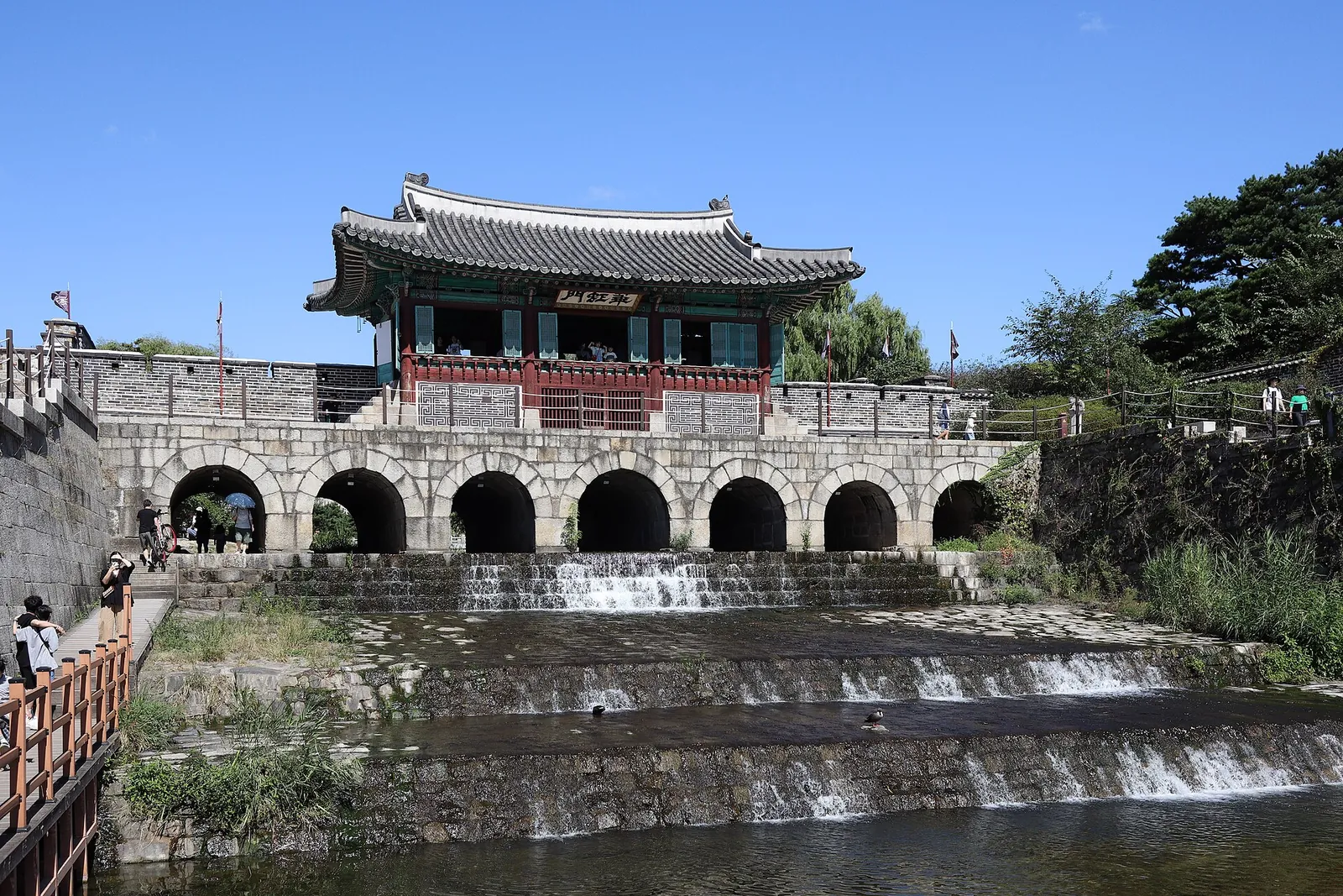 Hwahongmun, the arched stone water gate of Hwaseong Fortress with a pavilion on top, above the stream Suwoncheon