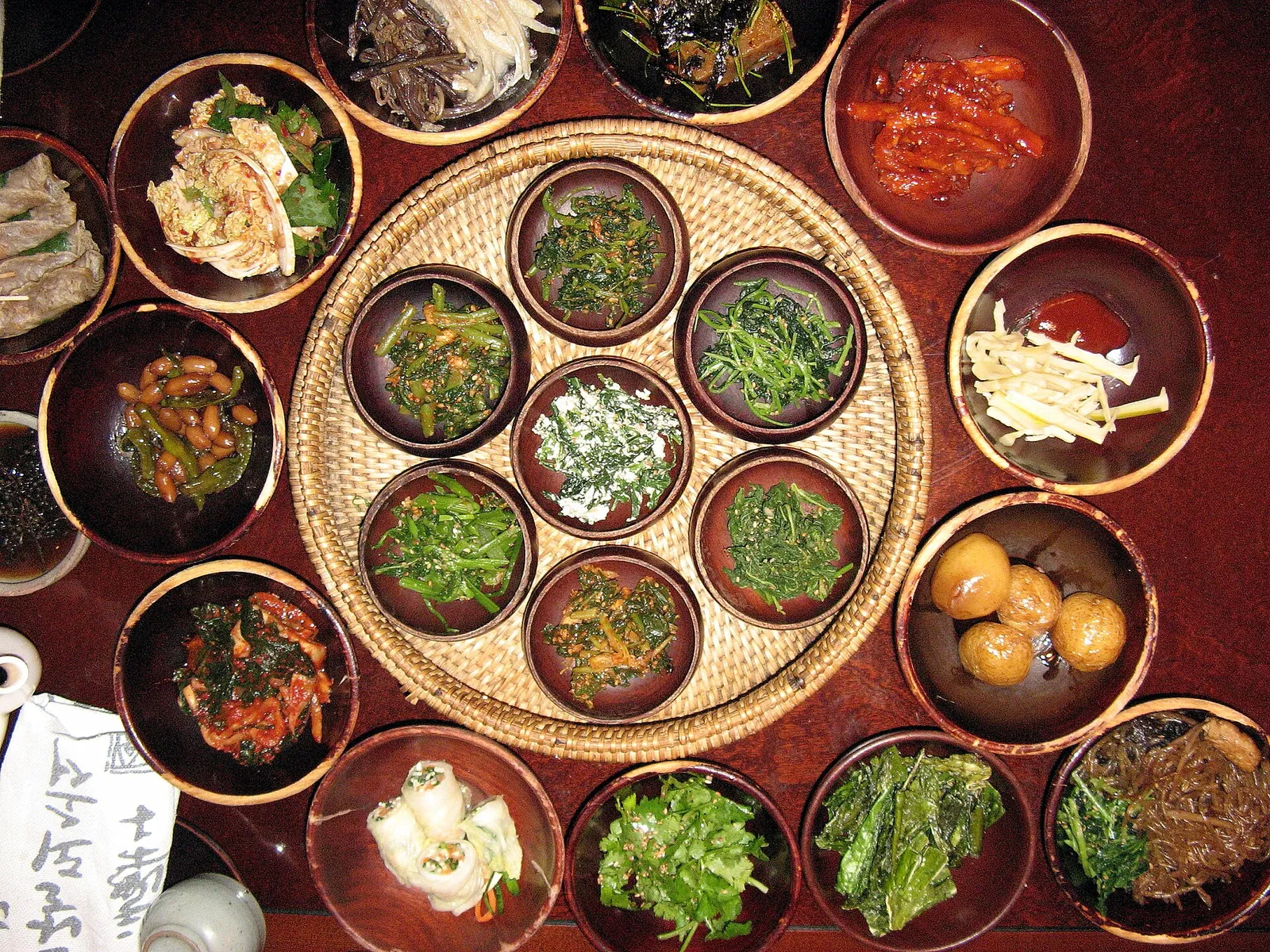 A round table of many small vegetable side dishes at a Korean temple-food restaurant