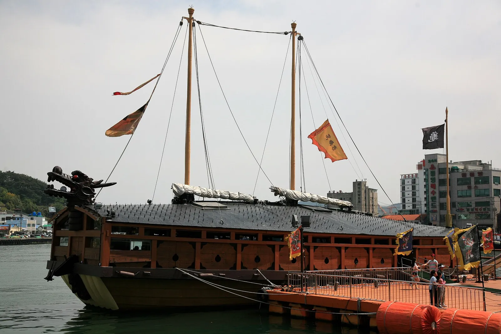 Replica of a Joseon turtle ship with flags and masts moored in Gangguan Port, Tongyeong