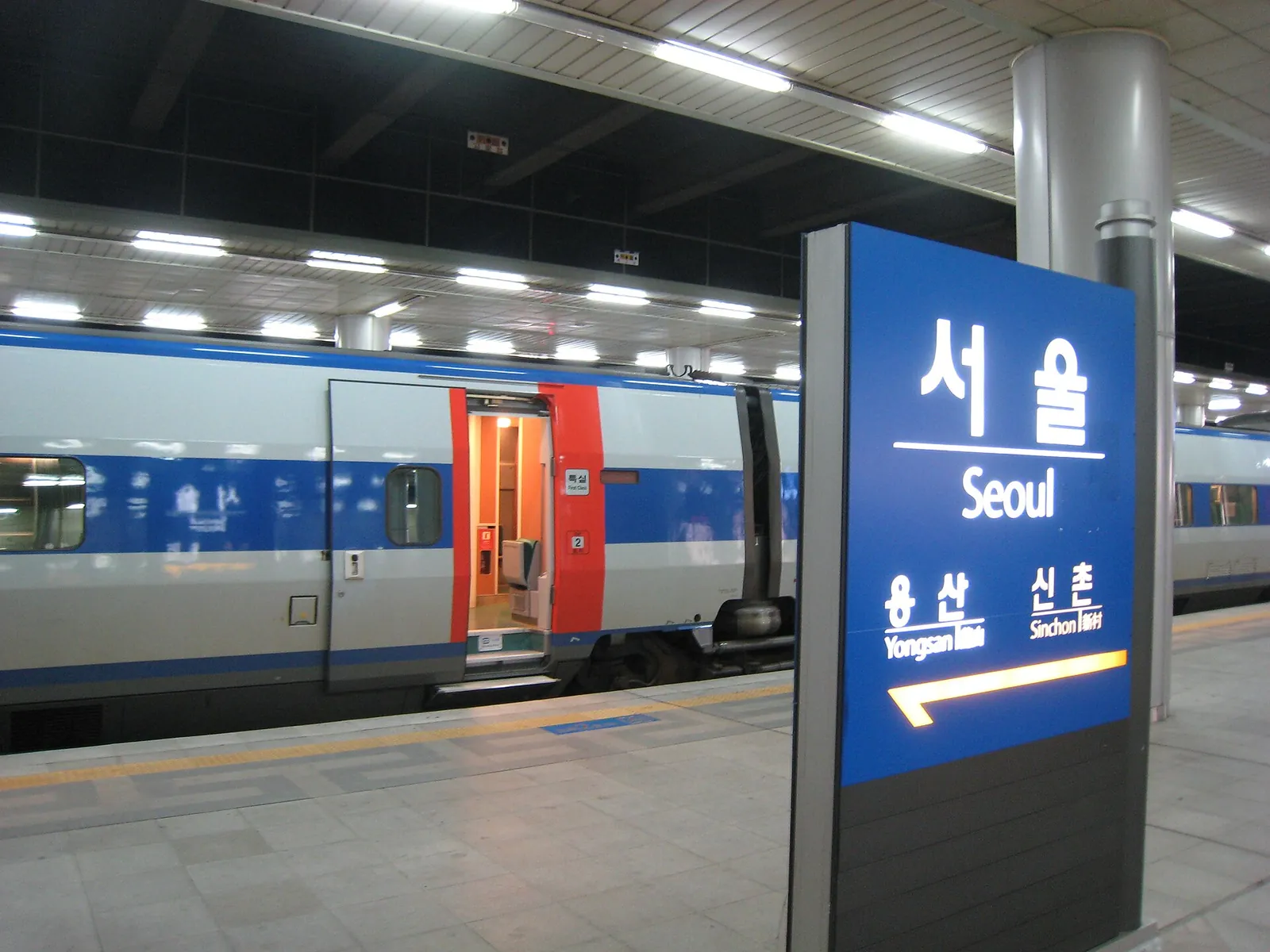 KTX train at a platform beside the blue Seoul Station sign