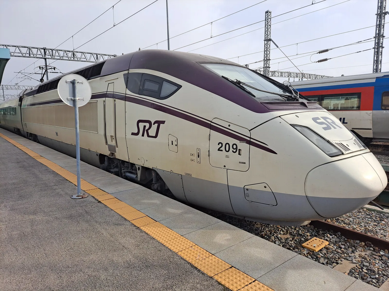 White and purple SRT high-speed train standing at a station platform