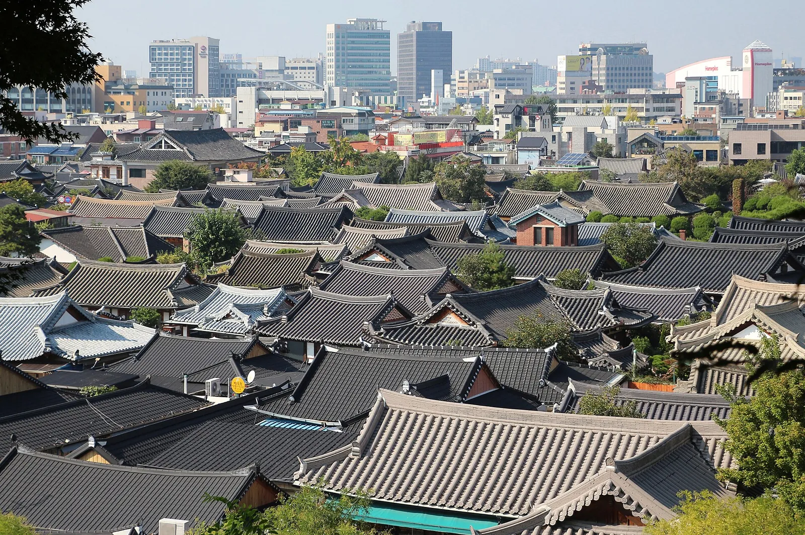 View over the tiled roofs of Jeonju Hanok Village with the city's high-rise buildings behind