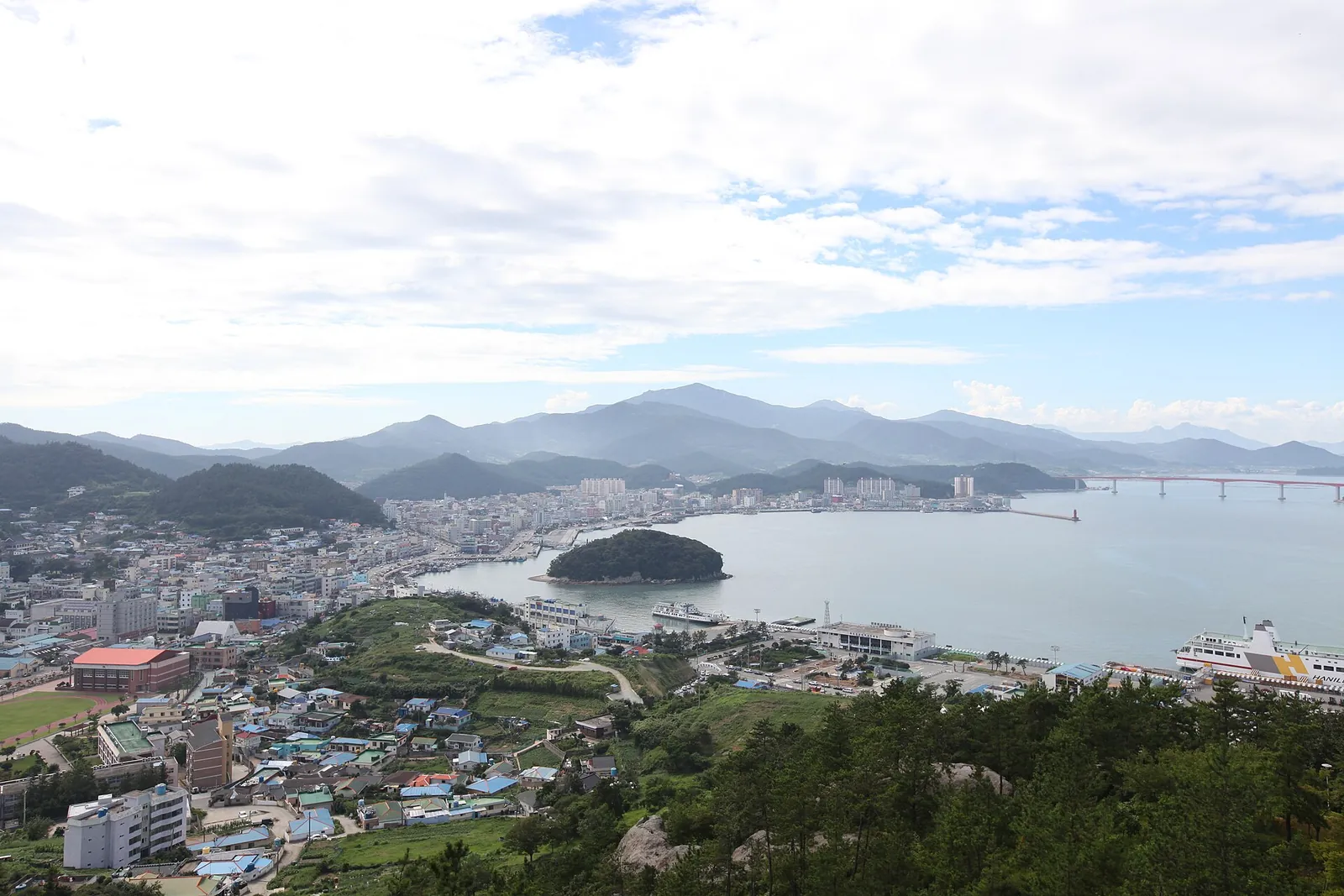 View over Wando-eup town and harbour with the small wooded islet of Judo offshore and hills beyond