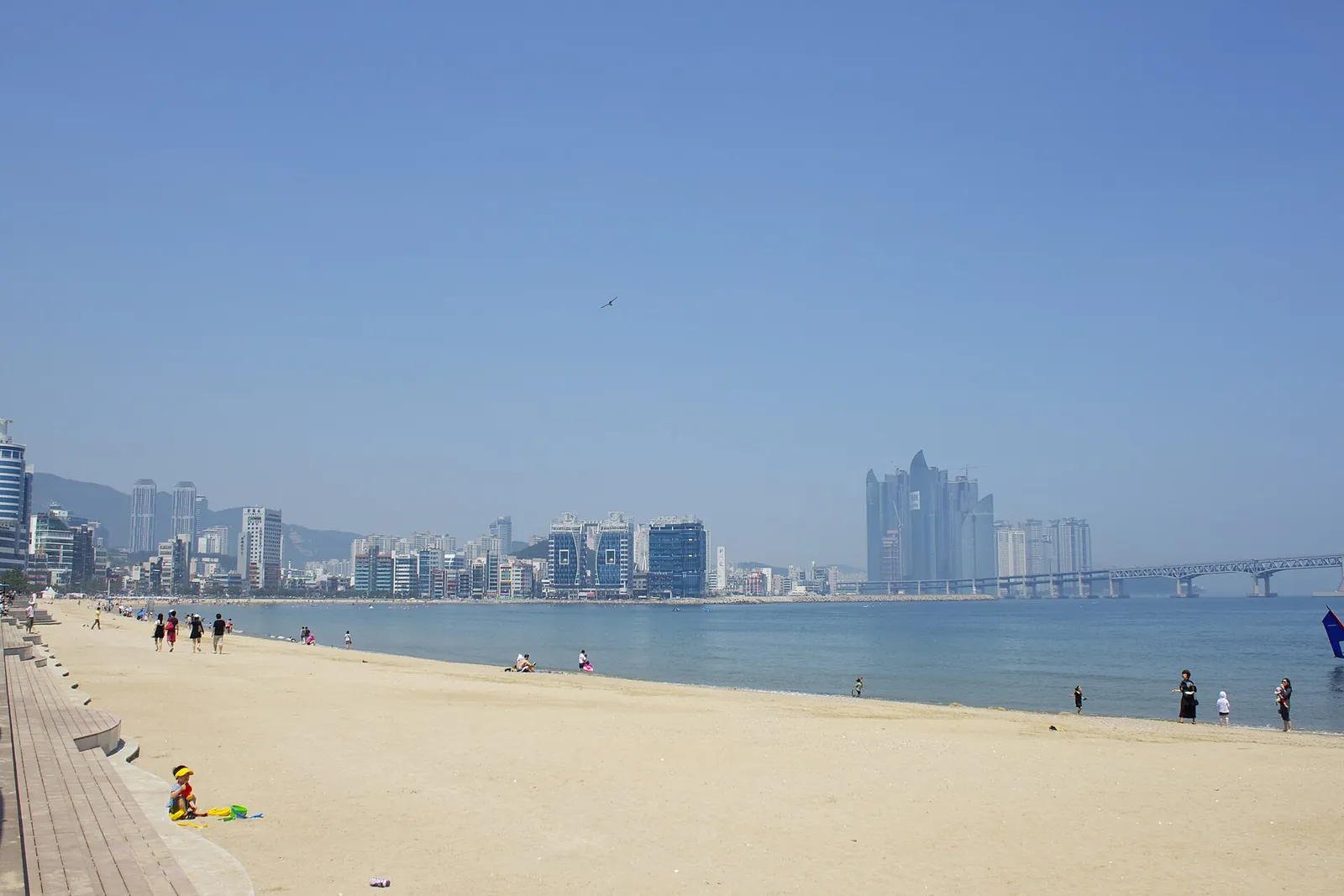 Gwangalli Beach in Busan with sand in the foreground and apartment and hotel towers along the bay