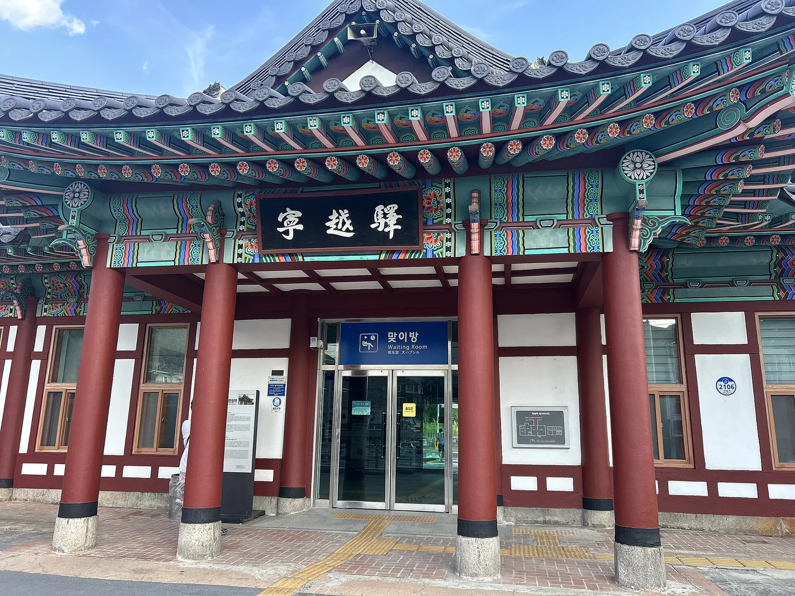 The entrance of Yeongwol Station, a hanok-style building with red pillars, painted eaves and a tiled roof