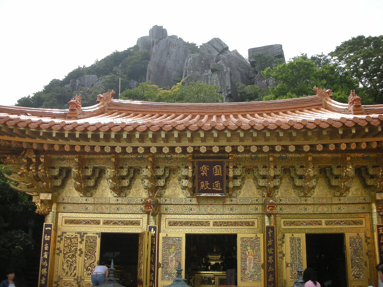 Ornate golden-doored hall at Hyangiram Hermitage beneath the rocky crags of Geumosan