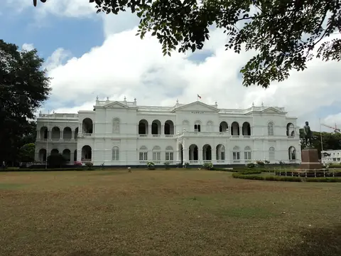 Das weiße Gebäude des Nationalmuseums Colombo im Kolonialstil, über den Rasen hinweg gesehen